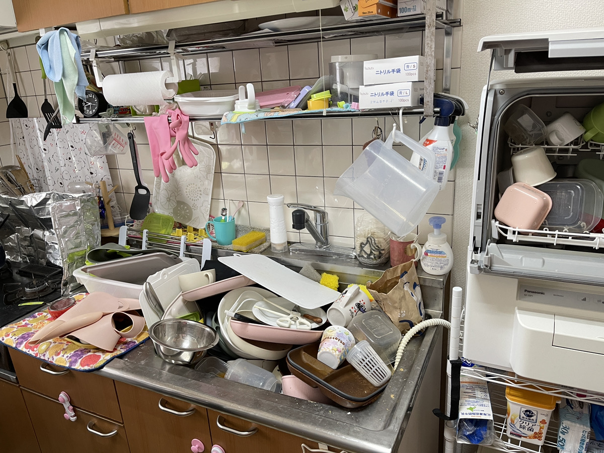 家事代行サービスを受ける前のキッチン。シンクや食器洗い機の中が洗い物で溢れている。